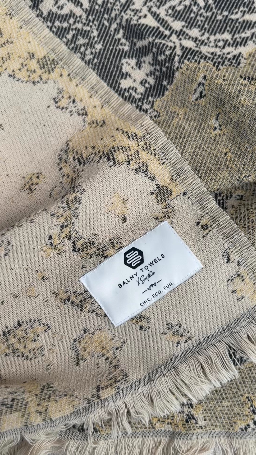 Gros plan du jeté GEORGIE et de son étiquette tissée Balmy Towels x Saskia