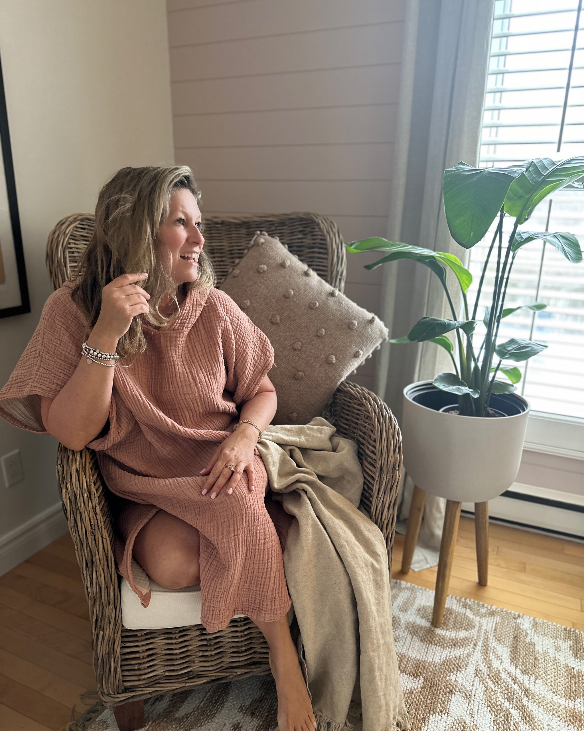 Femme assise dans un fauteuil en osier, vêtue du poncho MIA