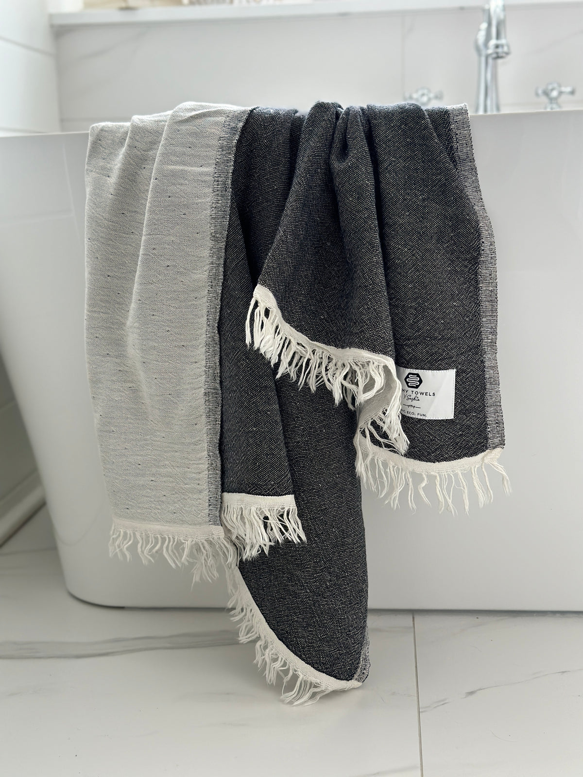 Our beautiful Napoli Towel in black on the side of the bathtub