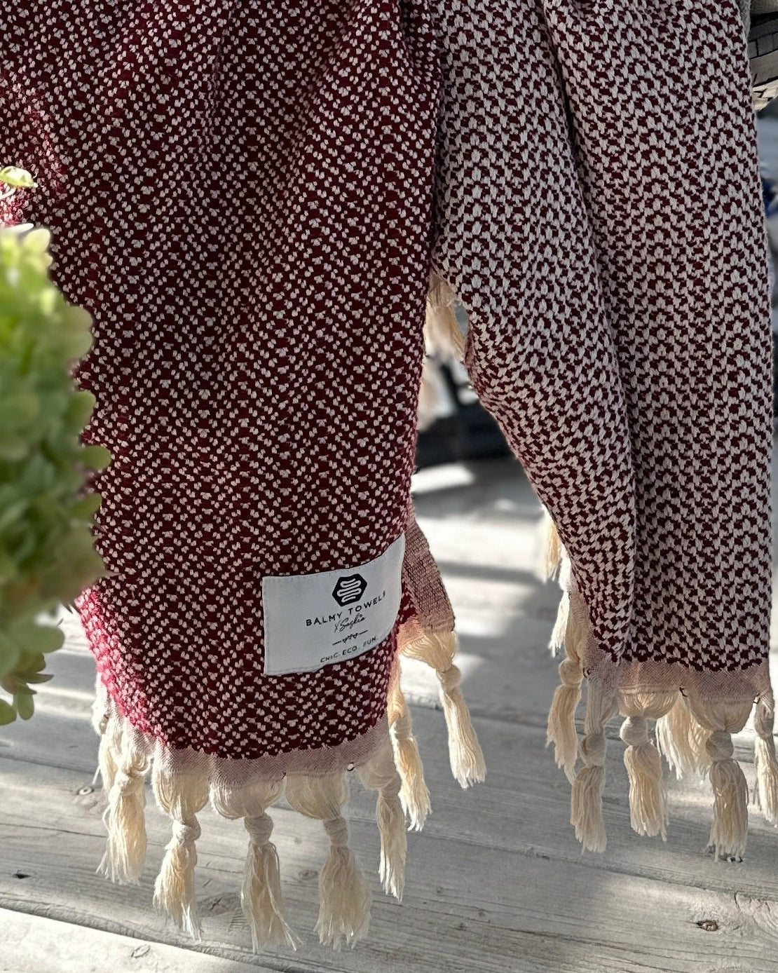 Étiquette tissée Balmy Towels x Saskia et franges nouées du jeté LIONEL bordeaux