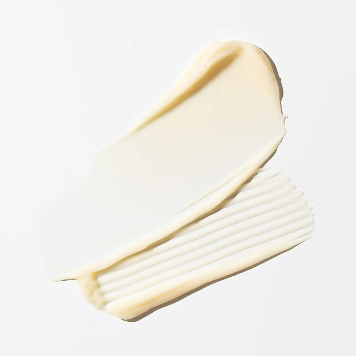 Deux traînées de crème ivoire du sérum jeunesse réparateur IMAGE MD d’Image Skincare sur fond blanc