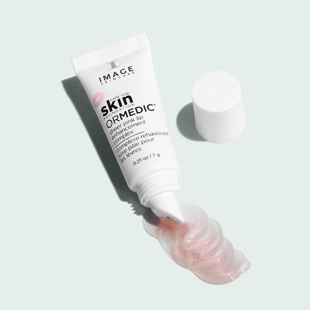Open Image Skincare ORMEDIC sheer pink lip enhancement complex tube, cap aside, a trail of pearly pink gloss