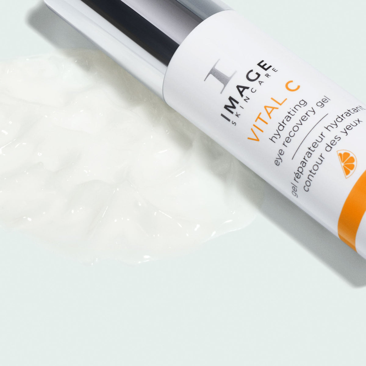 Flacon VITAL C gel réparateur hydratant contour des yeux d’Image Skincare couché près d’une trace de gel blanc