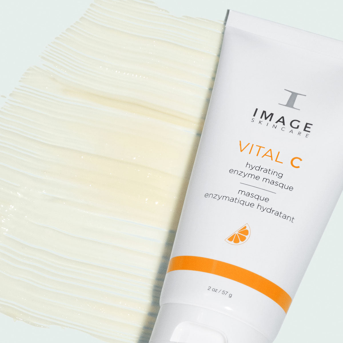 Tube blanc et orange, masque enzymatique hydratant VITAL C d’Image Skincare, à côté d’une large trace de texture crème