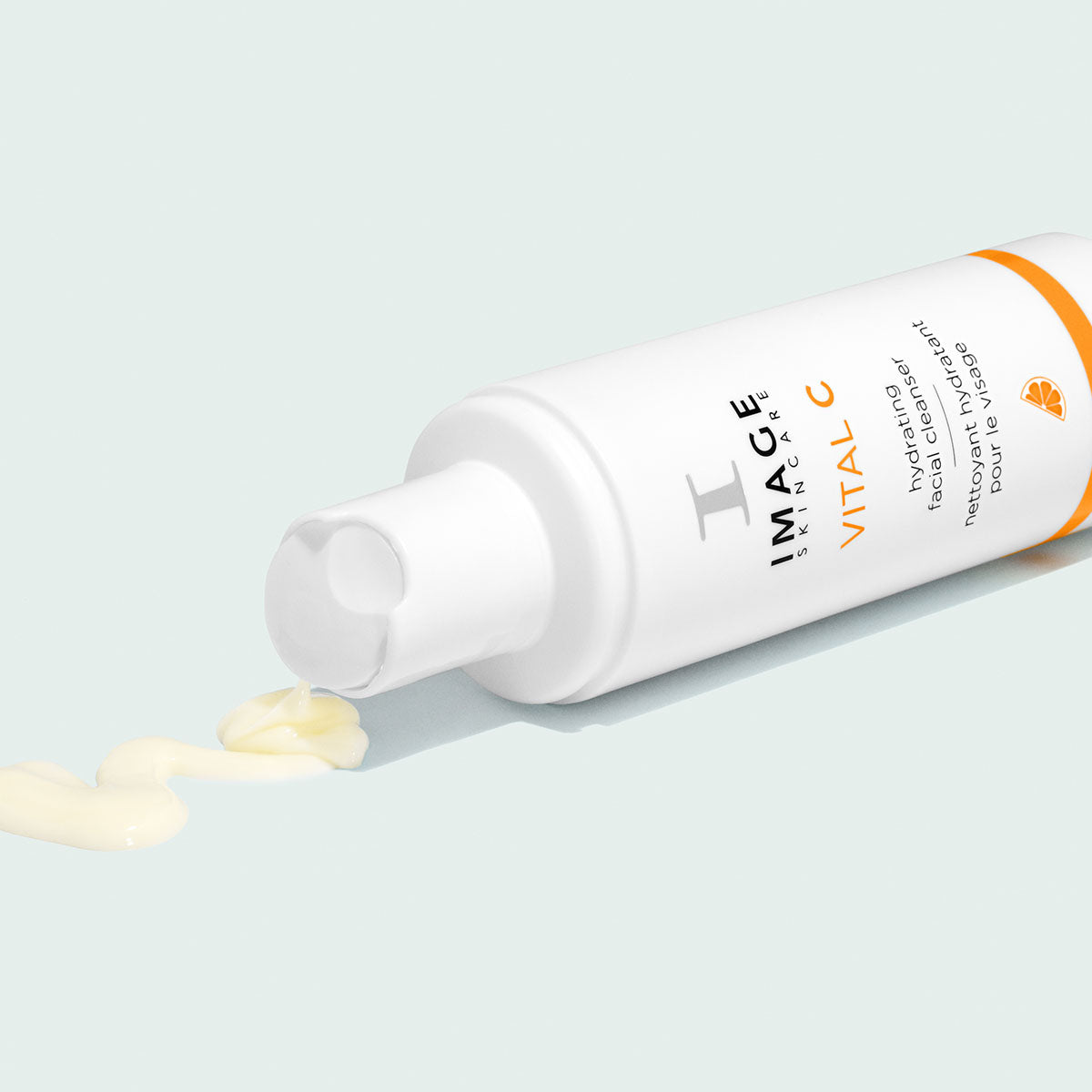 Flacon blanc et orange couché, nettoyant hydratant VITAL C d’Image Skincare, filet de nettoyant crème jaune pâle