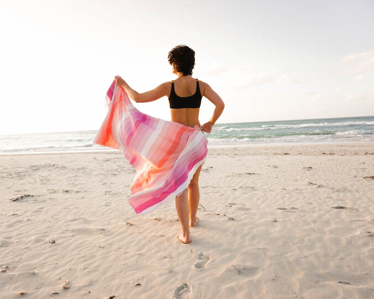 Woman walking at the beach showing her Balmy Sundae towel